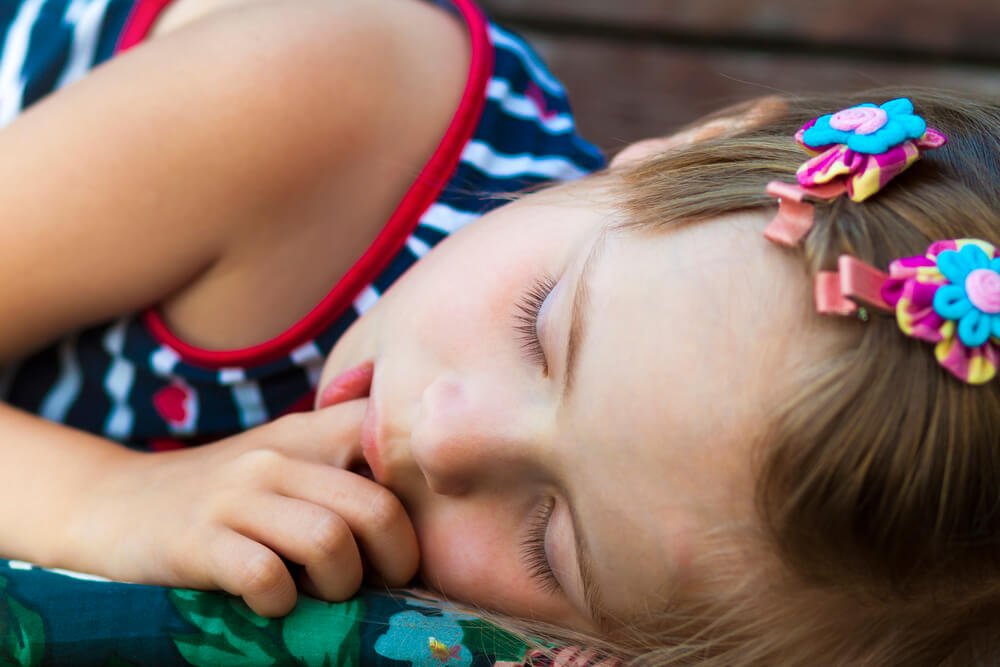 A sleeping little girl with a thumb sucking habit needing to see a Shingle Springs family dentist