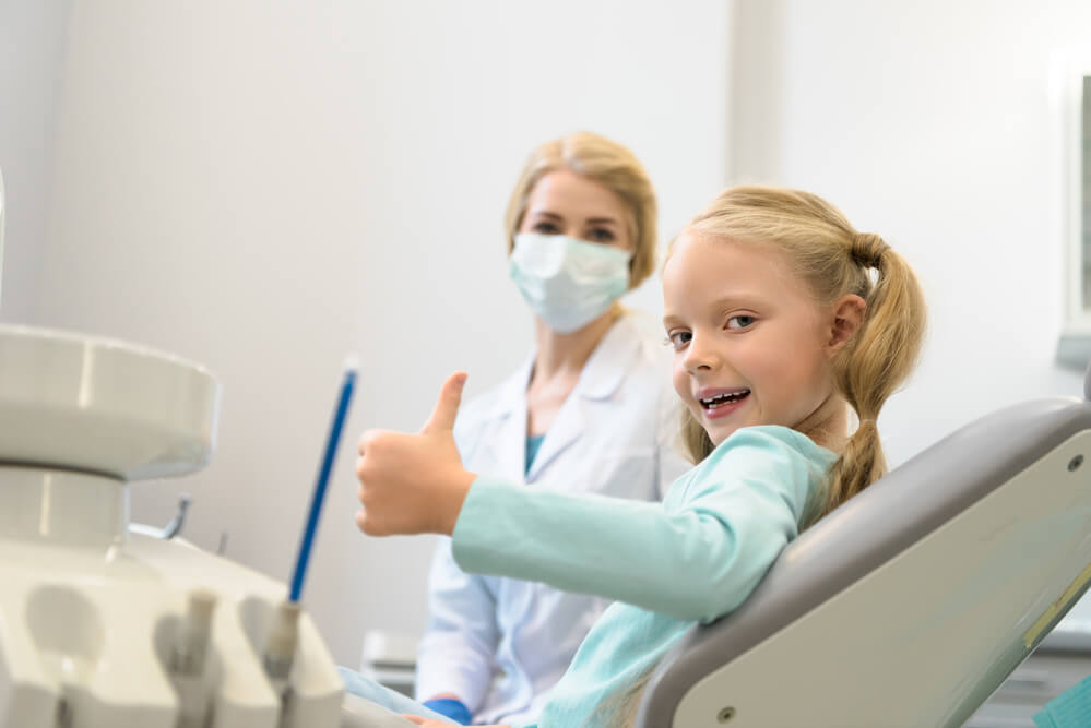 A little girl giving a thumbs up sign before receiving treatment from a Shingle Springs Family Dentist