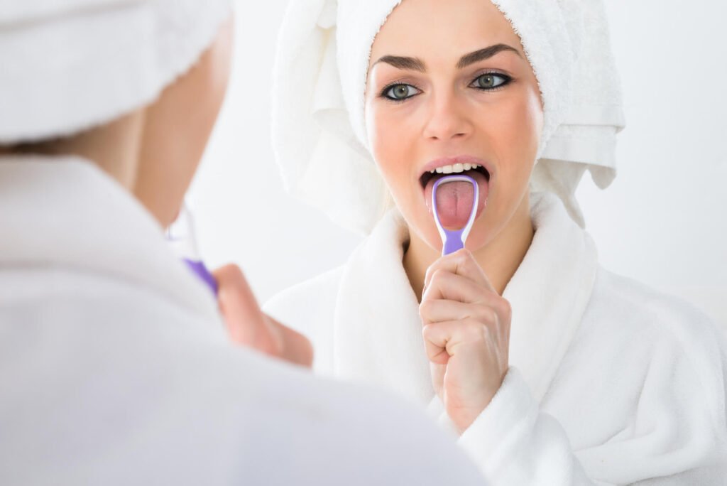 a woman cleaning her tongue as instructed by her Shingle Springs Dentist